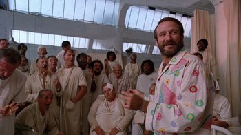 Movie still from “The Fisher King” (1991), directed by Terry Gilliam – A group of men in white robes and a man in a pink shirt; Medium shot, Low angle