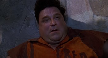 Movie still from “The Flintstones” (1994), directed by Brian Levant – A person laying on the ground; Close Up shot, Overhead angle