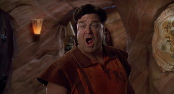 Movie still from “The Flintstones” (1994), directed by Brian Levant – A man in a brown and orange shirt is screaming; Close Up shot, Low angle
