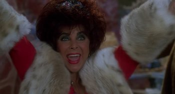 Movie still from “The Flintstones” (1994), directed by Brian Levant – An older woman with big green eyes wearing a fur coat; Close Up shot, High angle