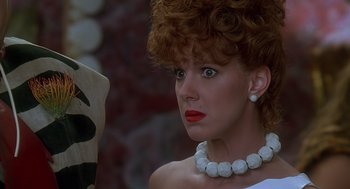 Movie still from “The Flintstones” (1994), directed by Brian Levant – A person wearing a necklace; Close Up shot, Low angle