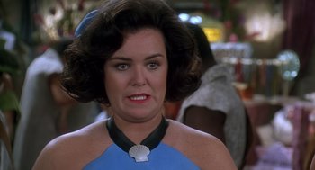 Movie still from “The Flintstones” (1994), directed by Brian Levant – A person wearing a necklace; Close Up shot, Over the shoulder angle