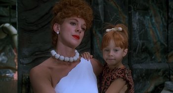 Movie still from “The Flintstones” (1994), directed by Brian Levant – A woman and a child are posing for a picture; Close Up shot, Low angle
