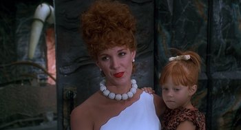 Movie still from “The Flintstones” (1994), directed by Brian Levant – A woman and a little girl are posing for a picture; Close Up shot, Low angle