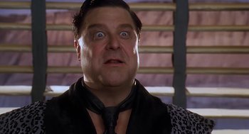 Movie still from “The Flintstones” (1994), directed by Brian Levant – A person wearing a suit and tie; Close Up shot, Low angle