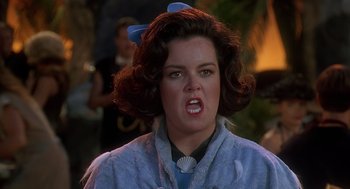 Movie still from “The Flintstones” (1994), directed by Brian Levant – A person with a bow on their head; Close Up shot, Over the shoulder angle