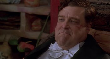 Movie still from “The Flintstones” (1994), directed by Brian Levant – A person wearing a suit and bow tie; Close Up shot, Low angle