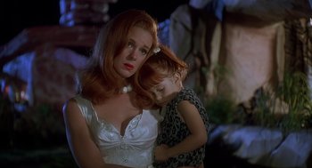 Movie still from “The Flintstones” (1994), directed by Brian Levant – A woman and a child are standing next to each other; Close Up shot, High angle