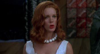 Movie still from “The Flintstones” (1994), directed by Brian Levant – A woman with red hair wearing a white dress; Close Up shot, Low angle