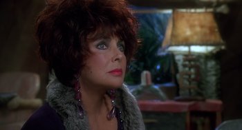 Movie still from “The Flintstones” (1994), directed by Brian Levant – A person wearing a fur coat and earrings; Close Up shot, Over the shoulder angle
