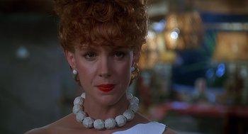Movie still from “The Flintstones” (1994), directed by Brian Levant – A person wearing a necklace; Close Up shot, Low angle