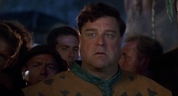 Movie still from “The Flintstones” (1994), directed by Brian Levant – A person with a crowd of people; Close Up shot, Over the shoulder angle