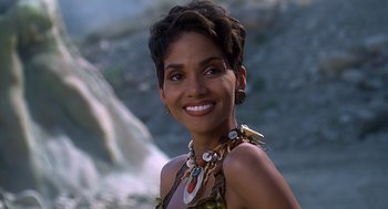 Movie still from “The Flintstones” (1994), directed by Brian Levant – A beautiful woman with short black hair wearing a necklace; Close Up shot, High angle