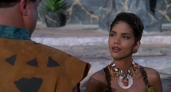 Movie still from “The Flintstones” (1994), directed by Brian Levant – A woman wearing a necklace with shells around her neck; Close Up shot, Over the shoulder angle