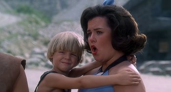 Movie still from “The Flintstones” (1994), directed by Brian Levant – A woman and a boy are hugging and making faces; Close Up shot, Over the shoulder angle