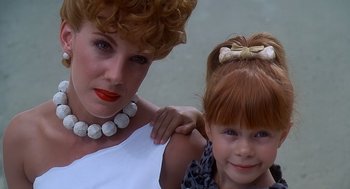 Movie still from “The Flintstones” (1994), directed by Brian Levant – A woman and a child pose for a picture; Close Up shot, Low angle