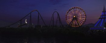 Movie still from “The Foreigner” (2017), directed by Martin Campbell – A ferris wheel and roller coaster at night; Extreme Wide shot, High angle