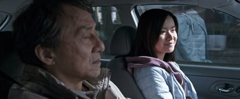 Movie still from “The Foreigner” (2017), directed by Martin Campbell – A man and a woman sitting in the back seat of a car; Close Up shot, Over the shoulder angle