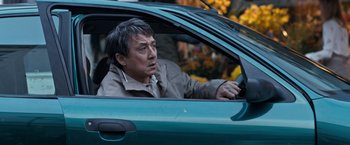 Movie still from “The Foreigner” (2017), directed by Martin Campbell – A man sitting in the driver's seat of a green car; Close Up shot, High angle