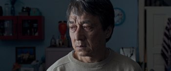 Movie still from “The Foreigner” (2017), directed by Martin Campbell – An older man looking sad while sitting in a room; Close Up shot, Over the shoulder angle