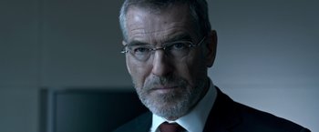 Movie still from “The Foreigner” (2017), directed by Martin Campbell – An older man wearing glasses and a suit; Close Up shot, Over the shoulder angle