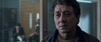 Movie still from “The Foreigner” (2017), directed by Martin Campbell – A person wearing a jacket; Close Up shot, Over the shoulder angle