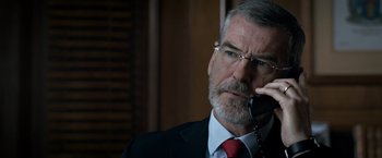 Movie still from “The Foreigner” (2017), directed by Martin Campbell – An older man in a suit and tie talking on a phone; Close Up shot, Over the shoulder angle