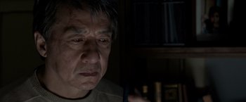 Movie still from “The Foreigner” (2017), directed by Martin Campbell – An older man is looking at a cell phone in a dark room; Close Up shot, Low angle