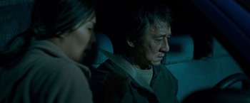 Movie still from “The Foreigner” (2017), directed by Martin Campbell – An older man and a younger woman sitting in a car at night; Close Up shot, Over the shoulder angle