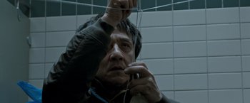 Movie still from “The Foreigner” (2017), directed by Martin Campbell – A man holding a wire in a bathroom; Close Up shot, Low angle