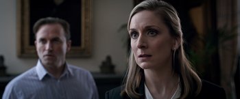 Movie still from “The Foreigner” (2017), directed by Martin Campbell – A woman with long blonde hair and blue eyes looking to her left; Close Up shot, Over the shoulder angle