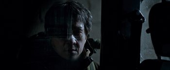 Movie still from “The Foreigner” (2017), directed by Martin Campbell – A man looking out of a window at night; Close Up shot, Low angle