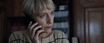 Movie still from “The Foreigner” (2017), directed by Martin Campbell – A person talking on a cell phone; Close Up shot, High angle