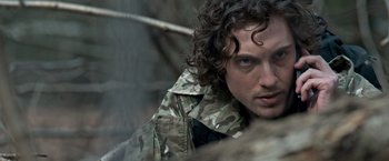 Movie still from “The Foreigner” (2017), directed by Martin Campbell – A person with curly hair wearing a jacket; Close Up shot, Over the shoulder angle