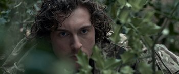 Movie still from “The Foreigner” (2017), directed by Martin Campbell – A person with curly brown hair; Extreme Close Up shot, Over the shoulder angle