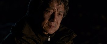 Movie still from “The Foreigner” (2017), directed by Martin Campbell – An older man wearing a brown jacket looking at the camera; Close Up shot, Low angle