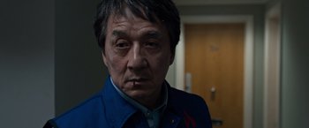 Movie still from “The Foreigner” (2017), directed by Martin Campbell – A person wearing a blue shirt; Close Up shot, Low angle