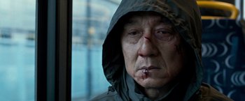 Movie still from “The Foreigner” (2017), directed by Martin Campbell – A person wearing a hooded jacket; Close Up shot, Low angle