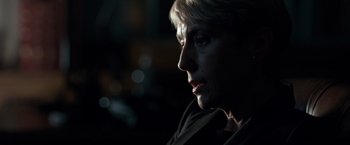 Movie still from “The Foreigner” (2017), directed by Martin Campbell – An older woman looking into the distance in the dark; Close Up shot, Over the shoulder angle