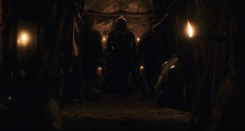 Movie still from “The Fountain” (2006), directed by Darren Aronofsky – A man sitting in a chair in a dark room with candles; Wide shot, Low angle