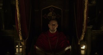 Movie still from “The Fountain” (2006), directed by Darren Aronofsky – A man sitting in a chair wearing a red robe; Medium shot, Low angle