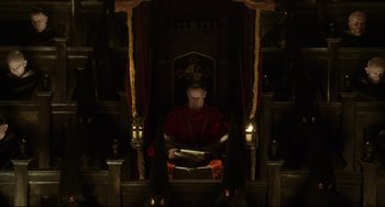 Movie still from “The Fountain” (2006), directed by Darren Aronofsky – A man sitting in a chair reading a book; Wide shot, High angle