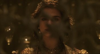 Movie still from “The Fountain” (2006), directed by Darren Aronofsky – A woman in a gold dress looking at the camera; Close Up shot, Over the shoulder angle