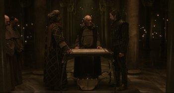 Movie still from “The Fountain” (2006), directed by Darren Aronofsky – A group of people standing around a table; Wide shot, High angle