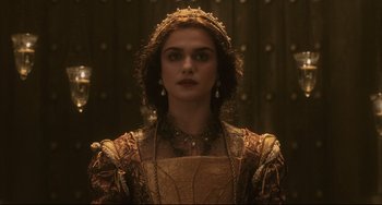 Movie still from “The Fountain” (2006), directed by Darren Aronofsky – A woman wearing a gold dress and a crown; Close Up shot, Over the shoulder angle