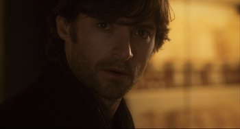 Movie still from “The Fountain” (2006), directed by Darren Aronofsky – A man's face in a dark room; Close Up shot, Over the shoulder angle