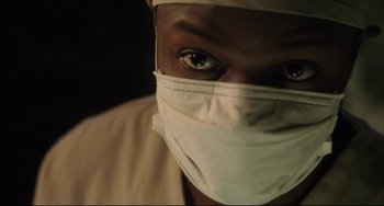 Movie still from “The Fountain” (2006), directed by Darren Aronofsky – A man wearing a surgical mask and a white hat; Close Up shot, Low angle