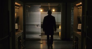 Movie still from “The Fountain” (2006), directed by Darren Aronofsky – A man in a black suit walking in front of an elevator; Wide shot, Low angle
