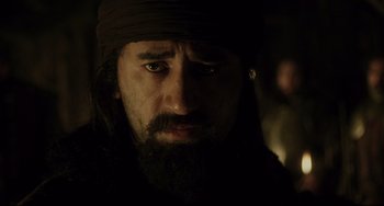 Movie still from “The Fountain” (2006), directed by Darren Aronofsky – A man with long hair and a beard wearing a black hat; Close Up shot, Over the shoulder angle