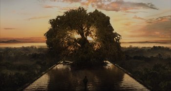 Movie still from “The Fountain” (2006), directed by Darren Aronofsky – A man standing in front of a large tree in the middle of a lake; Extreme Wide shot, Low angle